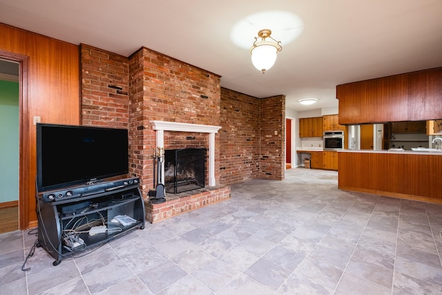 17 Wingate Dr, Little Rock, AR 72205 - unfurnished living room featuring a brick fireplace, wooden walls, a sink, and stone finish flooring