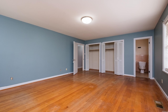17 Wingate Dr, Little Rock, AR 72205 - unfurnished bedroom with two closets, light wood-style floors, baseboards, and connected bathroom