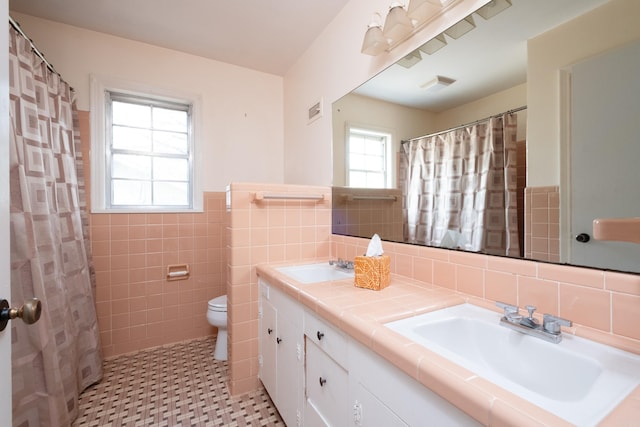 17 Wingate Dr, Little Rock, AR 72205 - bathroom with double vanity, tile walls, toilet, a wainscoted wall, and a shower with shower curtain