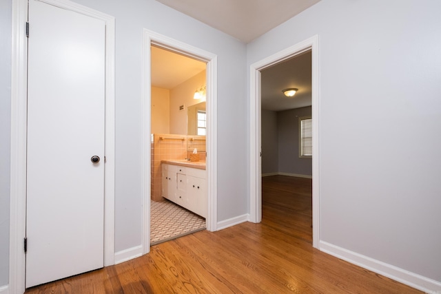 17 Wingate Dr, Little Rock, AR 72205 - hall featuring light wood-style flooring, baseboards, and a sink