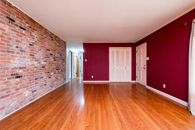 17 Wingate Dr, Little Rock, AR 72205 - unfurnished room featuring light wood-type flooring, brick wall, baseboards, and crown molding