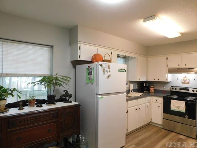 429 E Moore St, Heber Springs, AR 72543 - kitchen featuring electric range, freestanding refrigerator, under cabinet range hood, white cabinetry, and light wood-type flooring