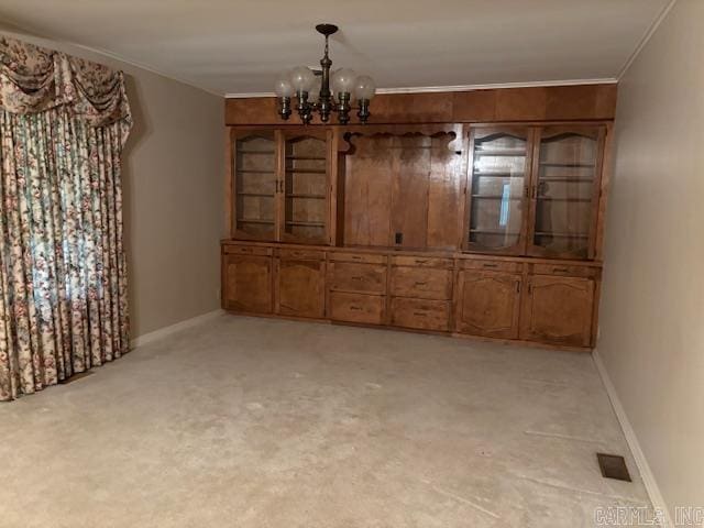 707 E Padgett, El Dorado, AR 71730 - unfurnished dining area featuring a chandelier, crown molding, light carpet, and baseboards