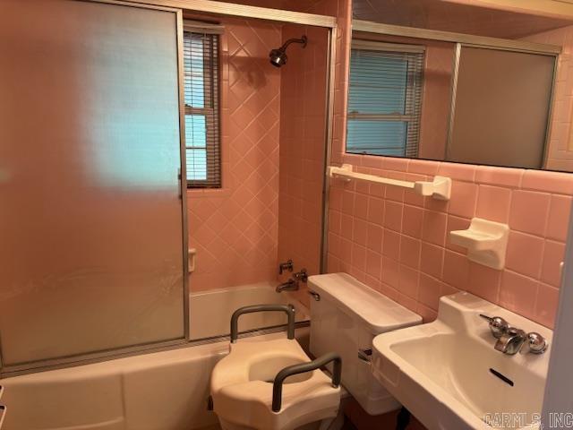 707 E Padgett, El Dorado, AR 71730 - bathroom featuring a sink, shower / bath combination with glass door, and toilet