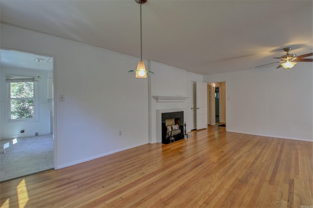 6800 Stamps Ct, Little Rock, AR 72207 - unfurnished living room featuring ceiling fan, light wood-type flooring, a fireplace with flush hearth, and baseboards