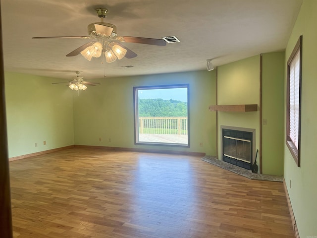 105 Traci Ln, Heber Springs, AR 72543 - unfurnished living room featuring wood finished floors, a fireplace, ceiling fan, and baseboards