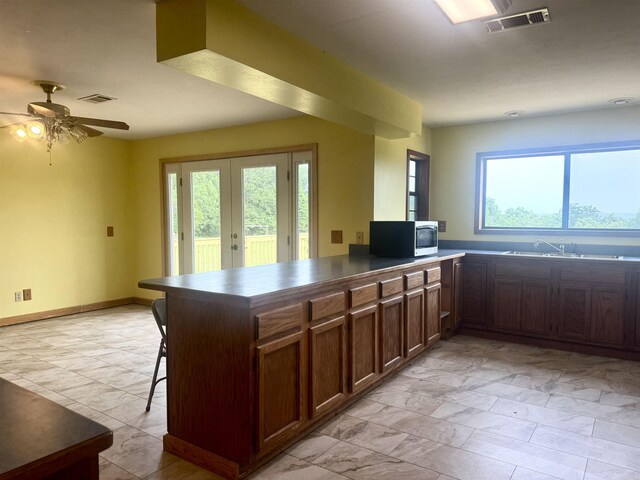 105 Traci Ln, Heber Springs, AR 72543 - kitchen featuring stainless steel microwave, a sink, a peninsula, french doors, and ceiling fan