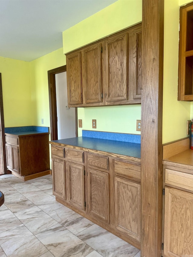 105 Traci Ln, Heber Springs, AR 72543 - kitchen featuring light marble finish floors, dark countertops, and brown cabinetry