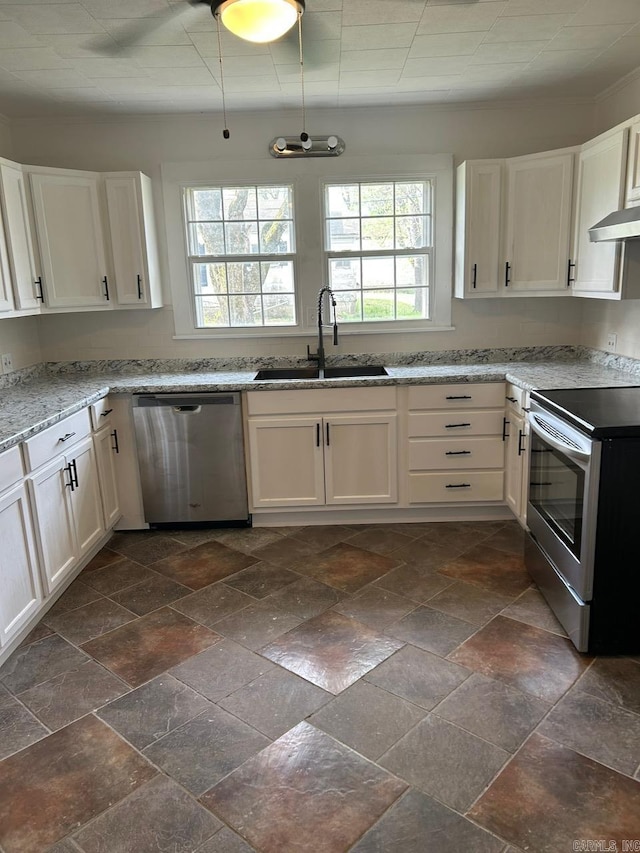 601 N Hickory, Searcy, AR 72143 - kitchen with appliances with stainless steel finishes, a sink, wall chimney range hood, stone tile floors, and white cabinets