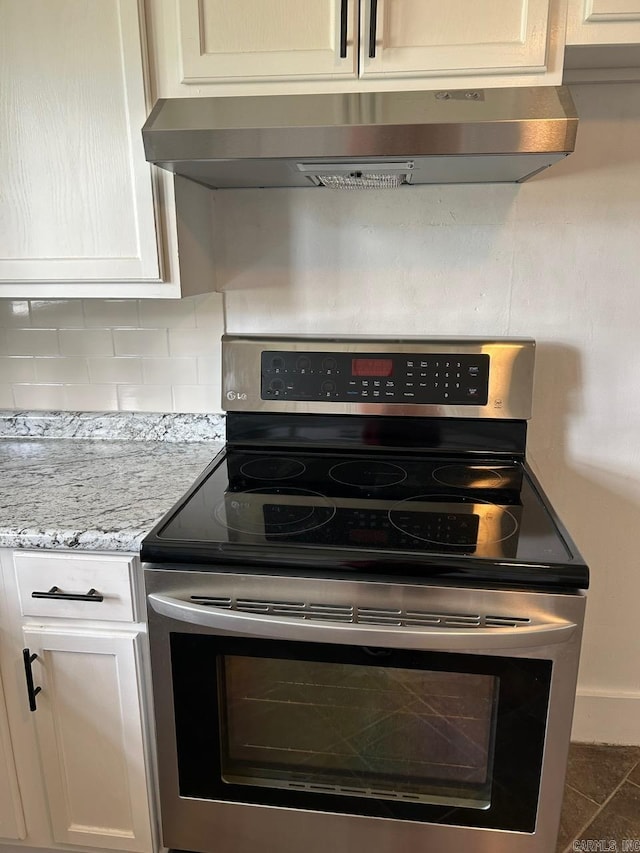 601 N Hickory, Searcy, AR 72143 - kitchen with stainless steel electric stove, tasteful backsplash, ventilation hood, white cabinetry, and light stone countertops