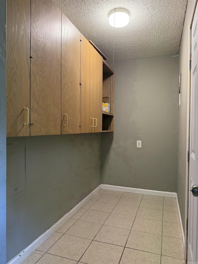 802 Desoto Pl, Benton, AR 72015 - clothes washing area featuring a textured ceiling, light tile patterned floors, and baseboards