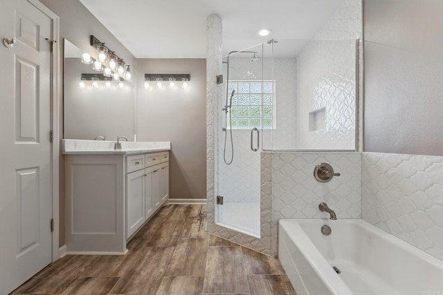19 Golden Oaks Cv, Maumelle, AR 72113 - bathroom featuring vanity, a stall shower, a garden tub, and wood finished floors