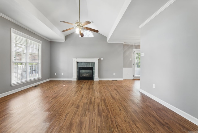 19 Golden Oaks Cv, Maumelle, AR 72113 - unfurnished living room featuring a ceiling fan, lofted ceiling, wood finished floors, a tiled fireplace, and crown molding