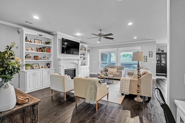 9224 Meadow Gardens Cir, Sherwood, AR 72120 - living room featuring crown molding, dark wood finished floors, a ceiling fan, recessed lighting, and a glass covered fireplace