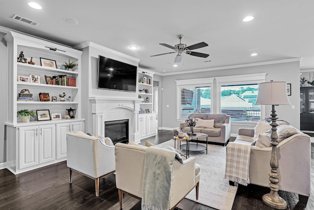 9224 Meadow Gardens Cir, Sherwood, AR 72120 - living area featuring dark wood finished floors, crown molding, a ceiling fan, a glass covered fireplace, and recessed lighting
