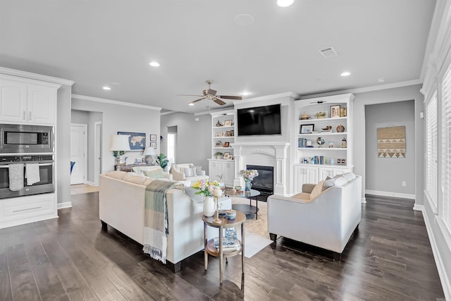 9224 Meadow Gardens Cir, Sherwood, AR 72120 - living room with ceiling fan, ornamental molding, dark wood finished floors, a glass covered fireplace, and recessed lighting