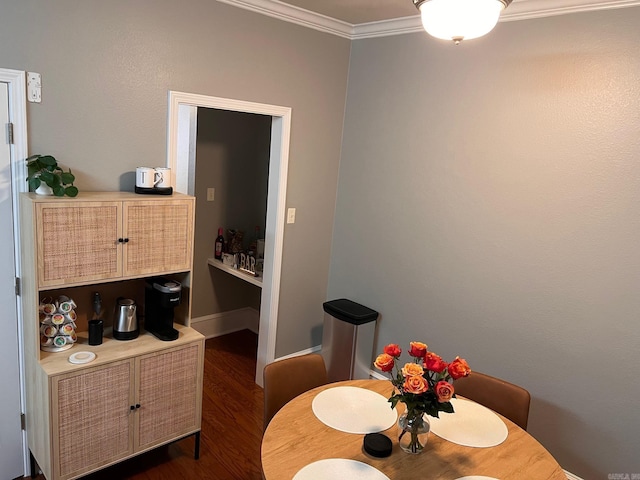 dining space with crown molding, dark wood finished floors, and baseboards