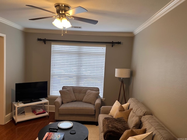 living area featuring wood finished floors, ceiling fan, crown molding, and baseboards