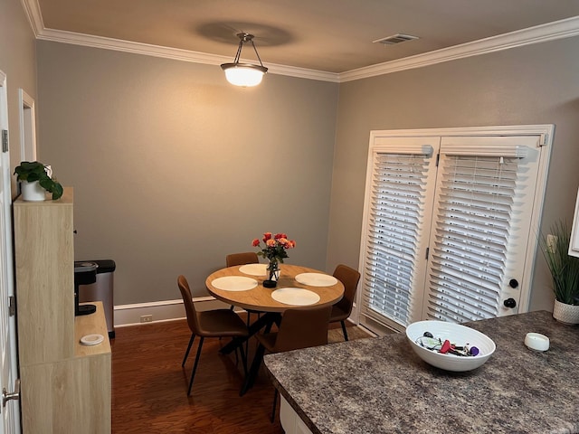 dining room featuring dark wood-style flooring, ornamental molding, and baseboards