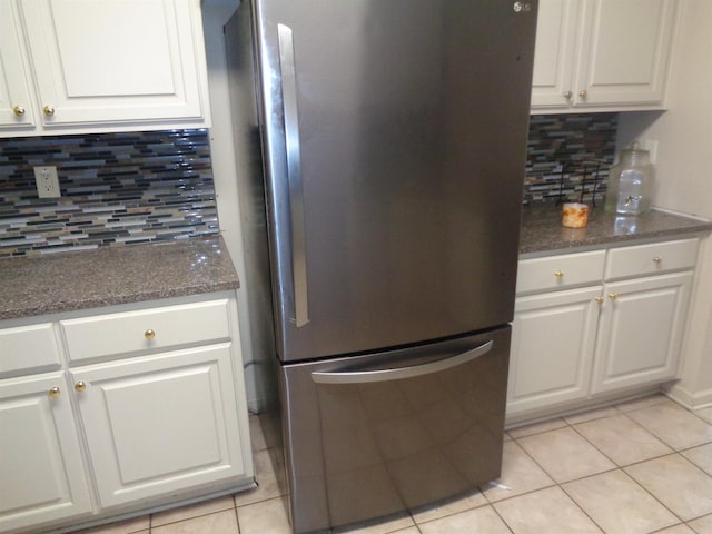 6 Jack Nicklaus Cv, Little Rock, AR 72210 - kitchen with freestanding refrigerator, backsplash, light tile patterned floors, and white cabinetry