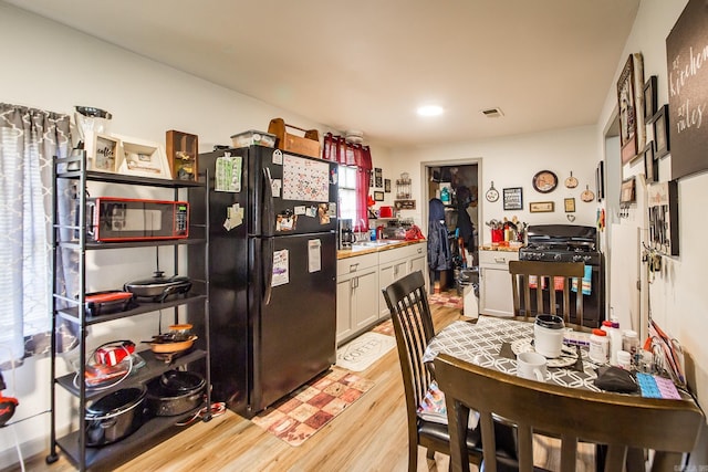 206 S Grant St, Cabot, AR 72023 - kitchen with freestanding refrigerator, gas range oven, light wood-style flooring, and light countertops