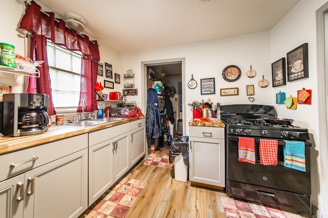 206 S Grant St, Cabot, AR 72023 - kitchen featuring black gas range, light wood-type flooring, and a sink