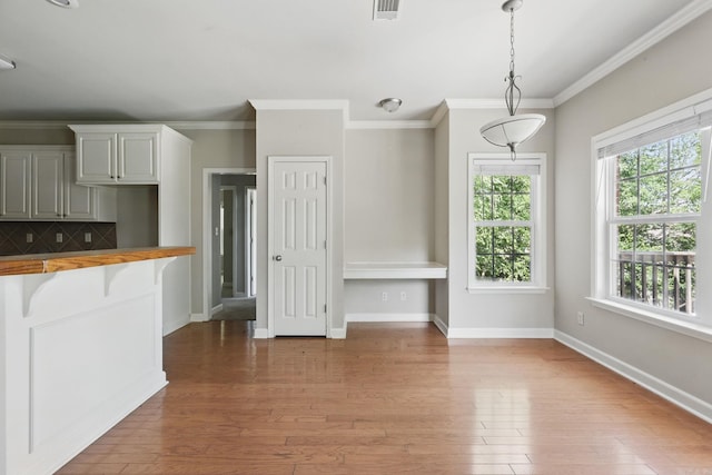 113 Shady Dr, Maumelle, AR 72113 - kitchen with wood finished floors, crown molding, baseboards, decorative backsplash, and decorative light fixtures