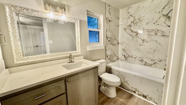 bathroom with wood finished floors, toilet, vanity, and washtub / shower combination