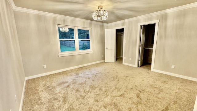 unfurnished bedroom with a chandelier, carpet floors, crown molding, baseboards, and connected bathroom