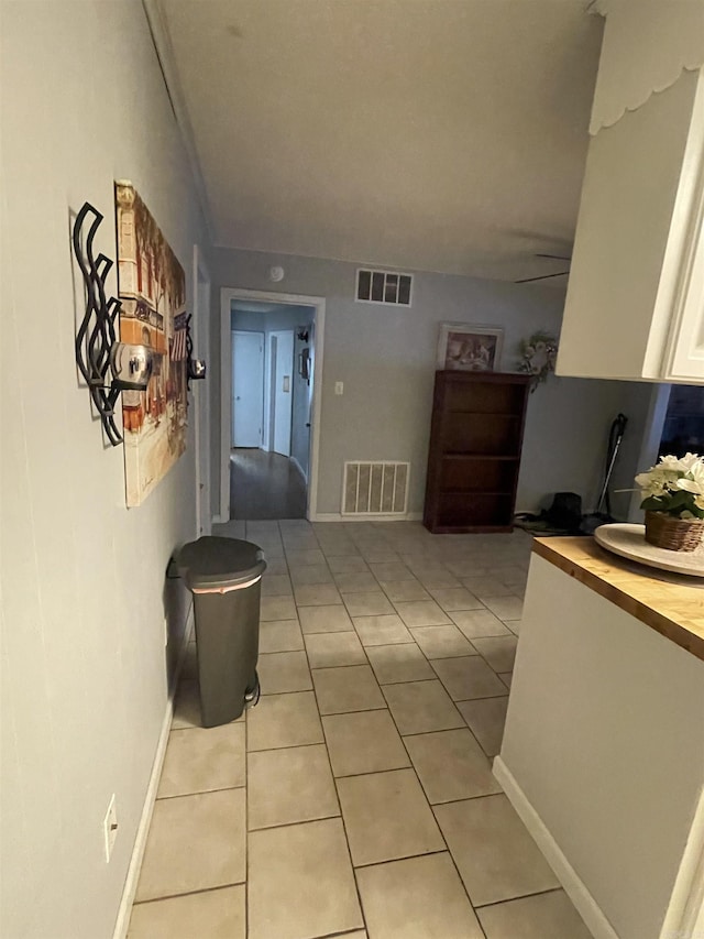hallway featuring light tile patterned floors and baseboards
