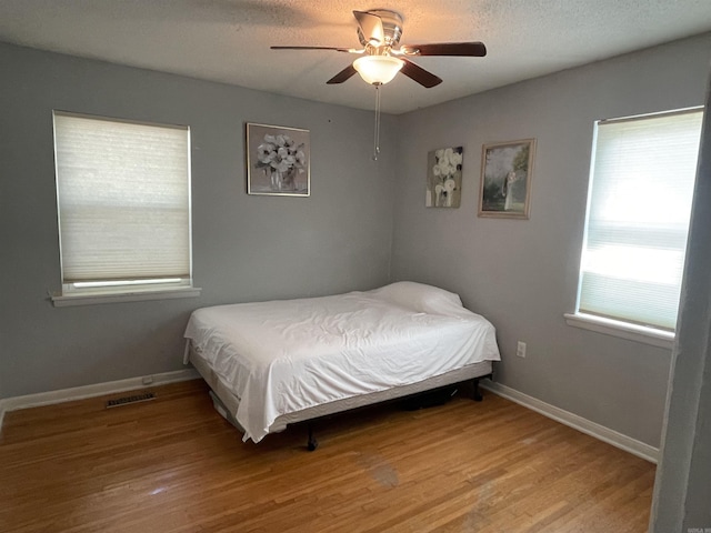 bedroom featuring light wood-style floors, baseboards, and a ceiling fan