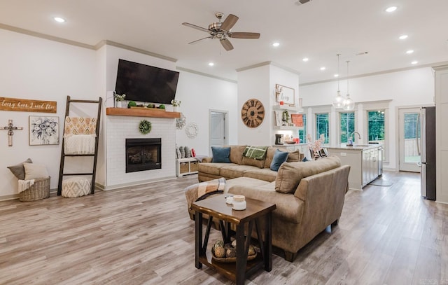 92 Hudson Dr, Sheridan, AR 72150 - living area with recessed lighting, a ceiling fan, light wood-style flooring, a fireplace, and crown molding