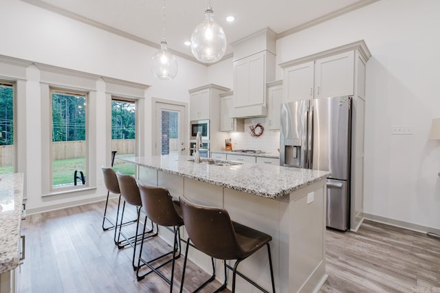 92 Hudson Dr, Sheridan, AR 72150 - kitchen featuring stainless steel appliances, light wood-type flooring, tasteful backsplash, a center island with sink, and ornamental molding