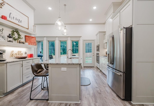 92 Hudson Dr, Sheridan, AR 72150 - kitchen featuring stainless steel appliances, a sink, a kitchen island with sink, open shelves, and light stone countertops