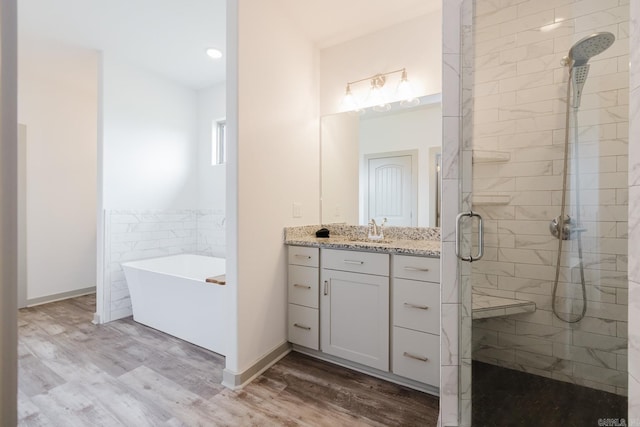 92 Hudson Dr, Sheridan, AR 72150 - full bath featuring a stall shower, wood finished floors, a soaking tub, vanity, and baseboards
