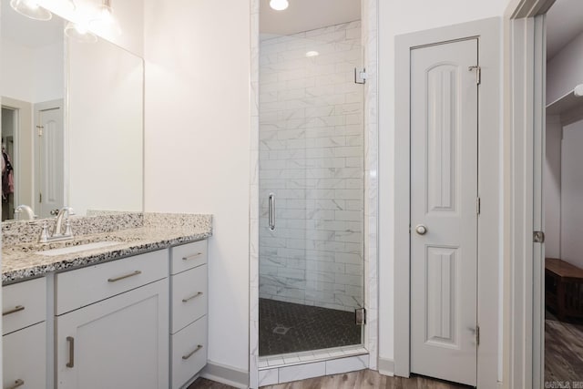 92 Hudson Dr, Sheridan, AR 72150 - full bathroom featuring wood finished floors, a shower stall, a closet, and vanity