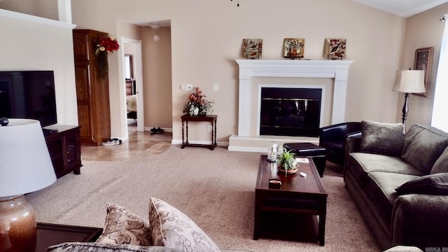 living area with carpet flooring, a glass covered fireplace, and baseboards