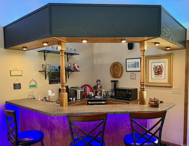 indoor wet bar featuring black microwave