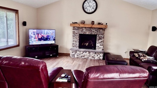 living area featuring wood finished floors, a fireplace, and baseboards
