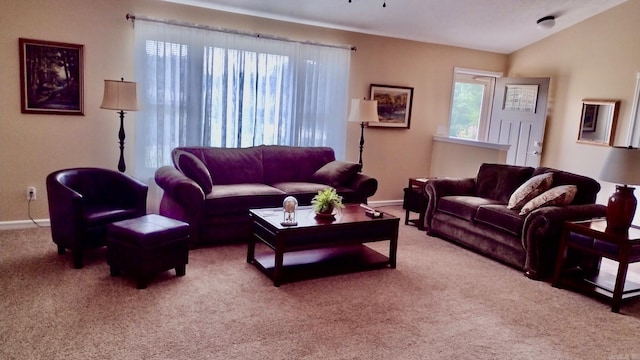 carpeted living area featuring baseboards and lofted ceiling