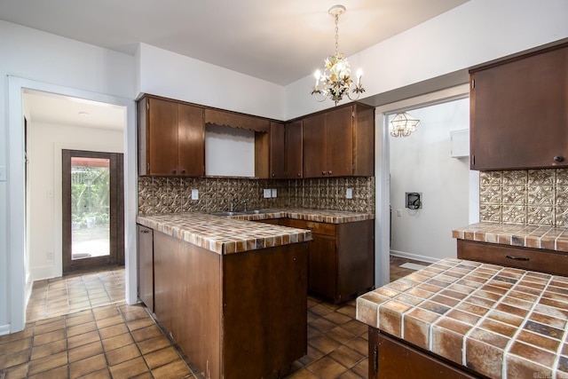 2108 Beechwood, Little Rock, AR 72207 - kitchen with tile countertops, a chandelier, a sink, tasteful backsplash, and dark brown cabinetry