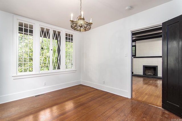 2108 Beechwood, Little Rock, AR 72207 - unfurnished dining area featuring wood-type flooring, baseboards, a chandelier, and plenty of natural light