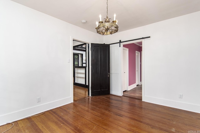 2108 Beechwood, Little Rock, AR 72207 - spare room featuring baseboards, wood finished floors, a chandelier, and a barn door