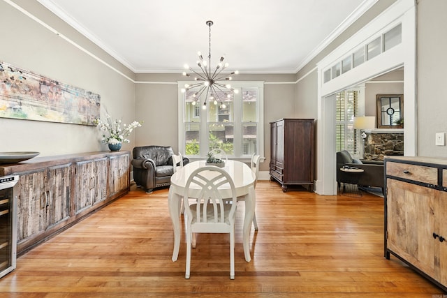 121 N Woodrow St, Little Rock, AR 72205 - dining space with a chandelier, light wood-type flooring, crown molding, and a stone fireplace