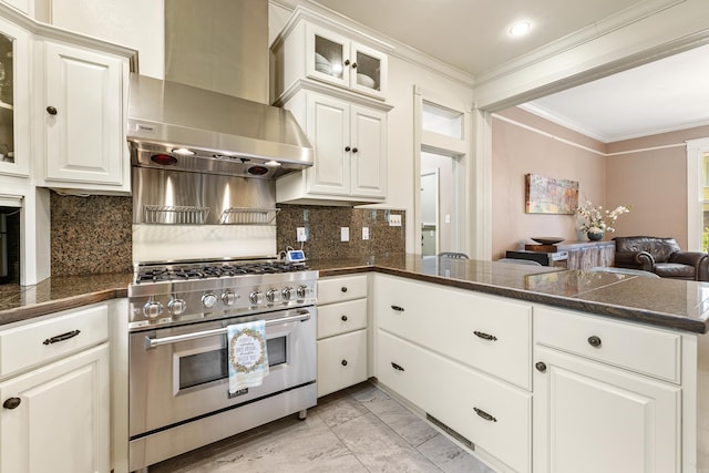 121 N Woodrow St, Little Rock, AR 72205 - kitchen with stainless steel range, crown molding, wall chimney range hood, a peninsula, and glass insert cabinets