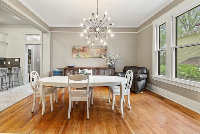 121 N Woodrow St, Little Rock, AR 72205 - dining room featuring a chandelier, light wood finished floors, crown molding, and baseboards