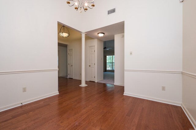 1505 Cherry Brook Dr, Little Rock, AR 72211 - unfurnished room with decorative columns, wood finished floors, a chandelier, baseboards, and a towering ceiling
