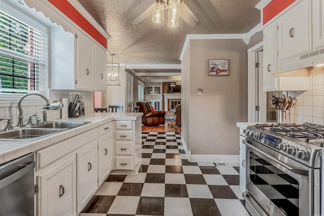 77 Stoneledge Dr, Maumelle, AR 72113 - kitchen with stainless steel appliances, a sink, tile counters, a textured ceiling, and white cabinetry