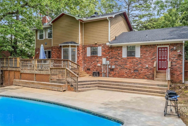 77 Stoneledge Dr, Maumelle, AR 72113 - rear view of property featuring brick siding, a chimney, a deck, an outdoor pool, and a patio area
