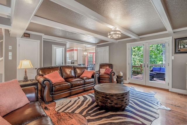 77 Stoneledge Dr, Maumelle, AR 72113 - living area with light wood-style flooring, a chandelier, a textured ceiling, beam ceiling, and baseboards